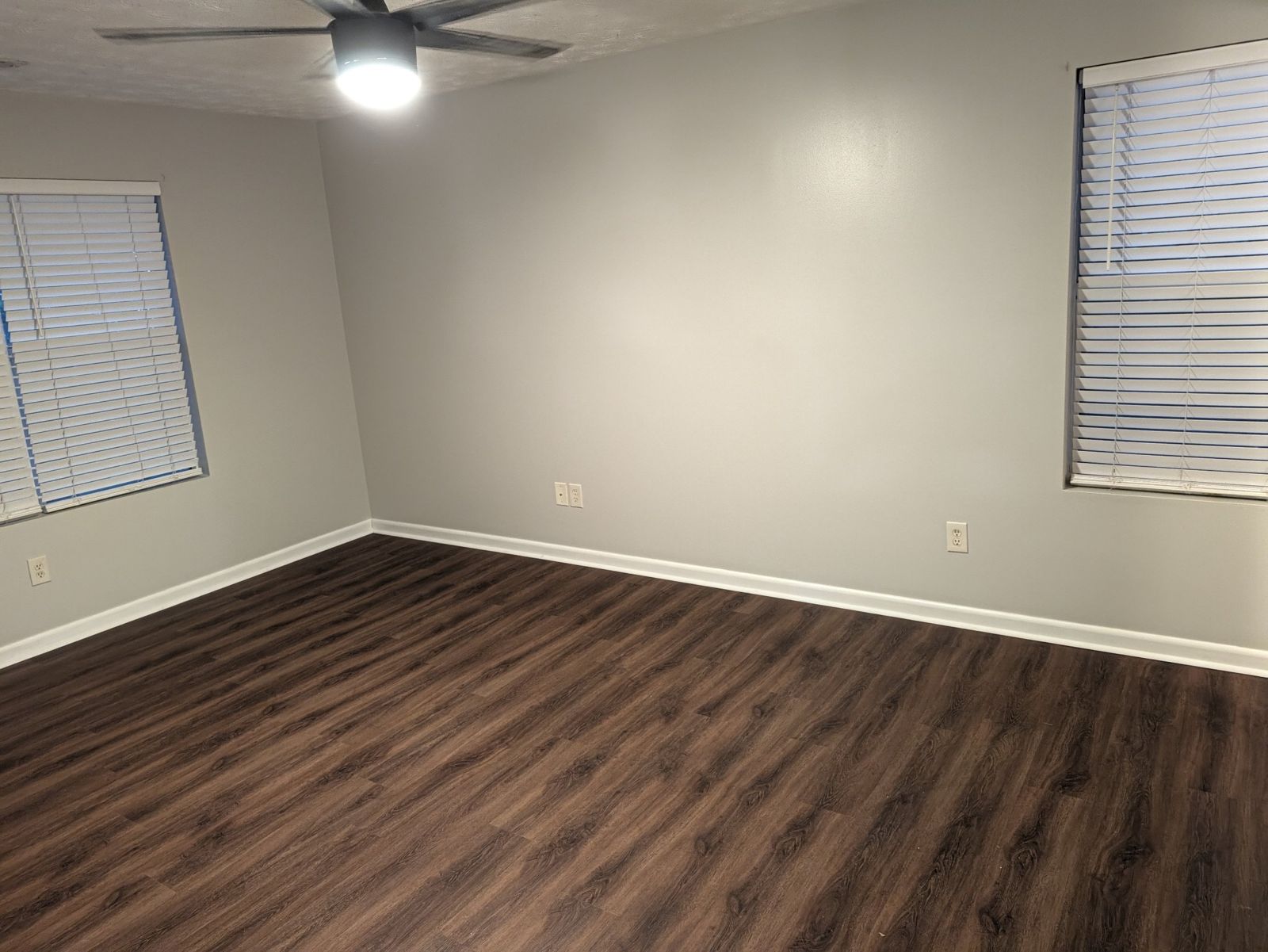 Large bedroom with two windows and a ceiling fan