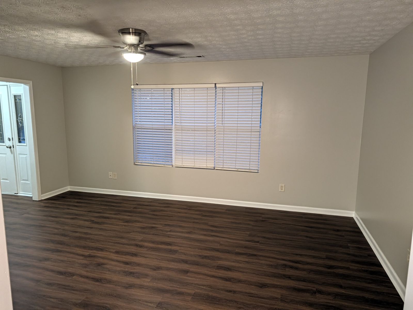 Living room with a wide triple window and ceiling fan